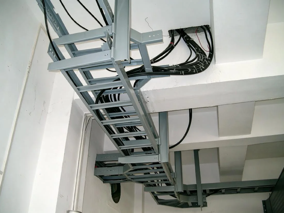 Overhead cable ladder with open rungs supporting electrical cables