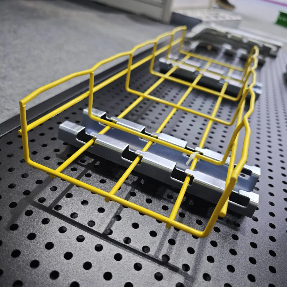 Yellow wire mesh cable tray mounted on metal support brackets